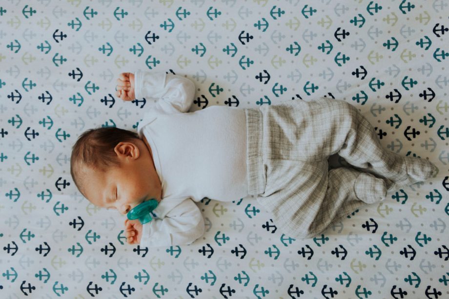 Infant sleeping on blanket with anchors