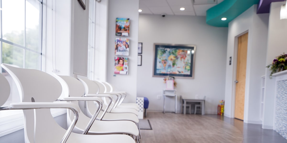 white chairs against window in dental office waiting area