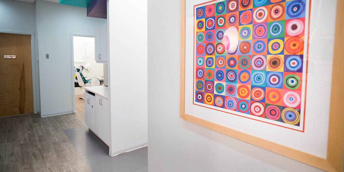 hallway in dental office with abstract colorful art on wall